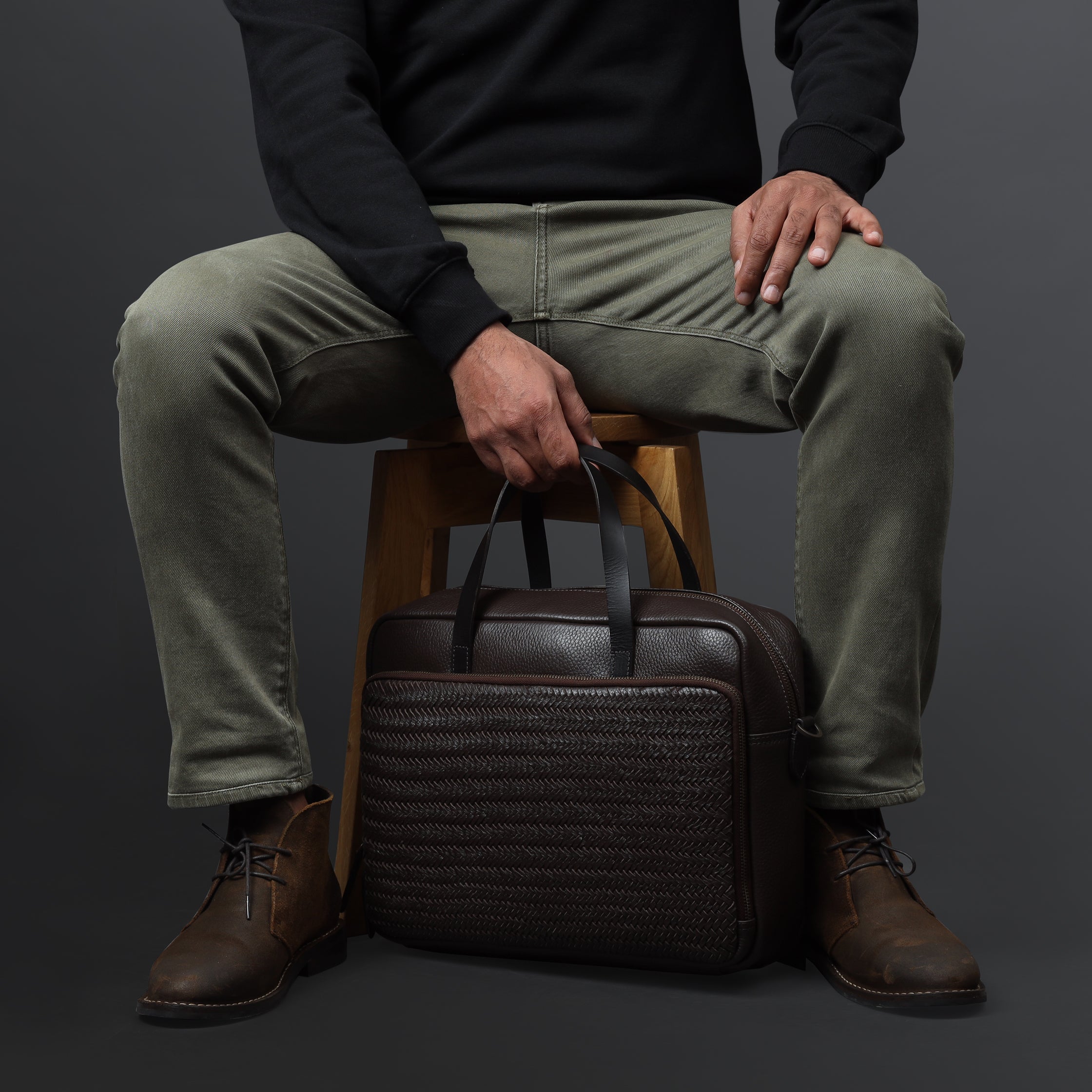 Model sitting down with Brown Boston Leather Briefcase Handcrafted from Sustainable Materials